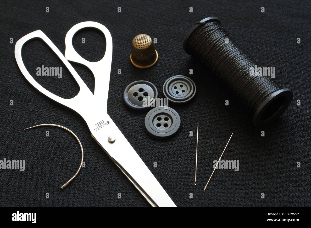 A set of various sewing accessories for sewing and needlework. Accessories for sewing on a dark background. Stock Photo