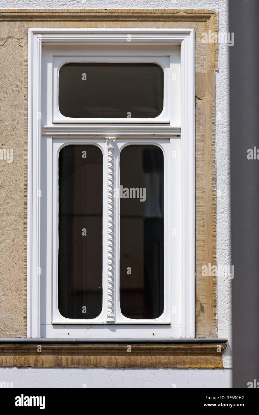 Ornate White Historic Window Framed by Sandstone on a Sunlit Facade Stock Photo