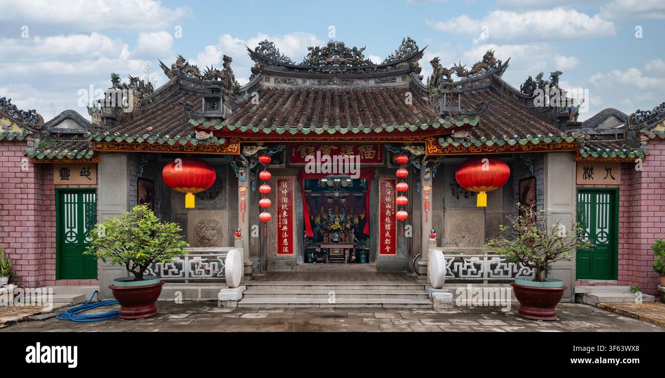 Hoi An, Vietnam - May 1, 2026: Traditional architecture of the historic Phuc Kien Assembly Hall featuring ornate roof details, hanging red lanterns, a Stock Photo