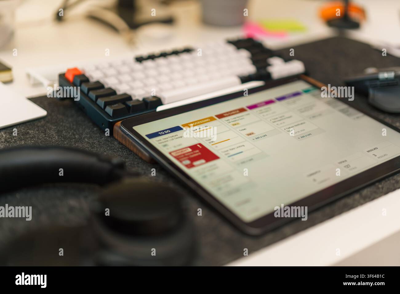Tablet Display Agile Kanban Board Software Development Workspace. Modern office desk setup featuring a digital tablet showing project management task Stock Photo