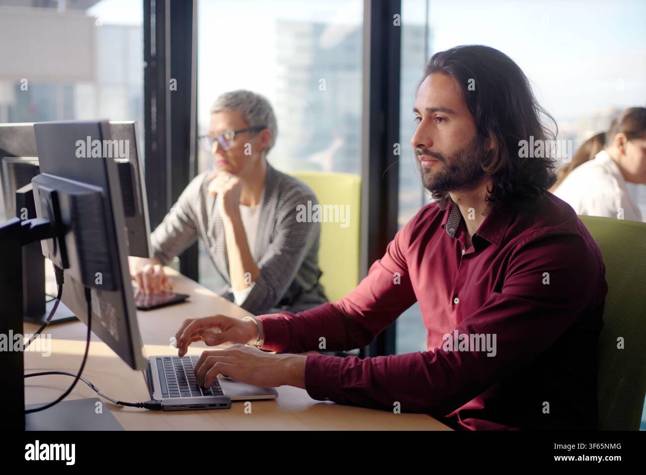 Focused businessman working on laptop in modern open office Stock Photo