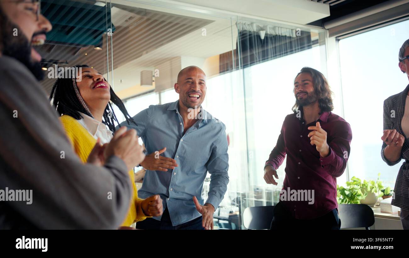 Diverse team celebrating in modern office Stock Photo