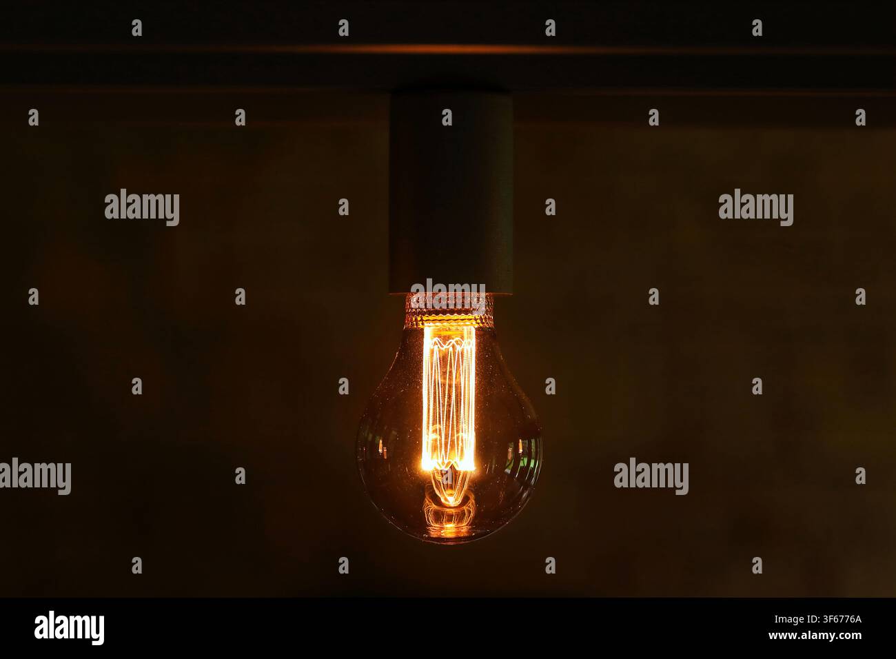 Light bulb switched on close up on dark background Stock Photo