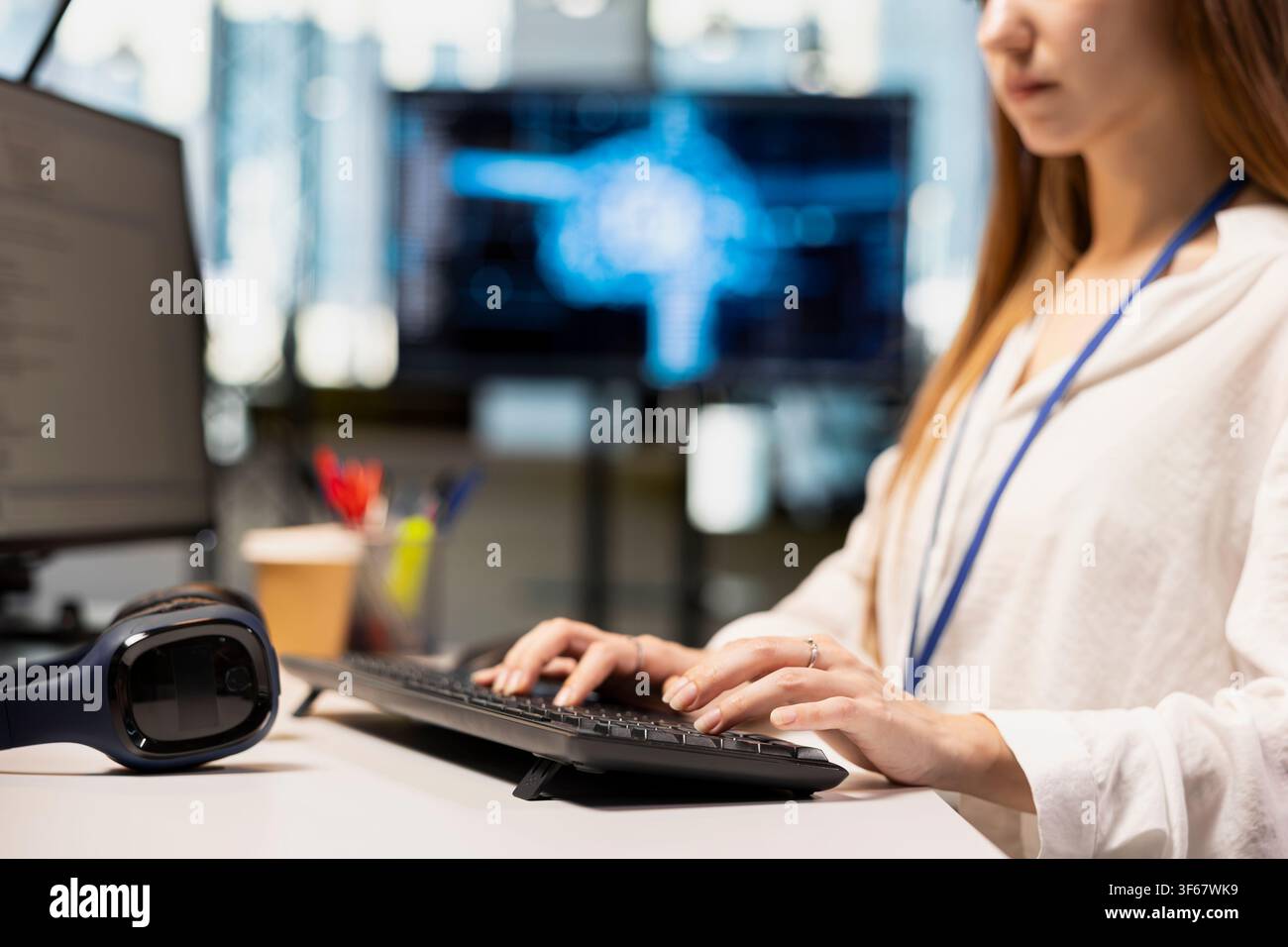 Close up of female engineer writing AI code, developing applications using PC in office. Worker doing internship in startup typing on keyboard, debugging applications using artificial intelligence Stock Photo
