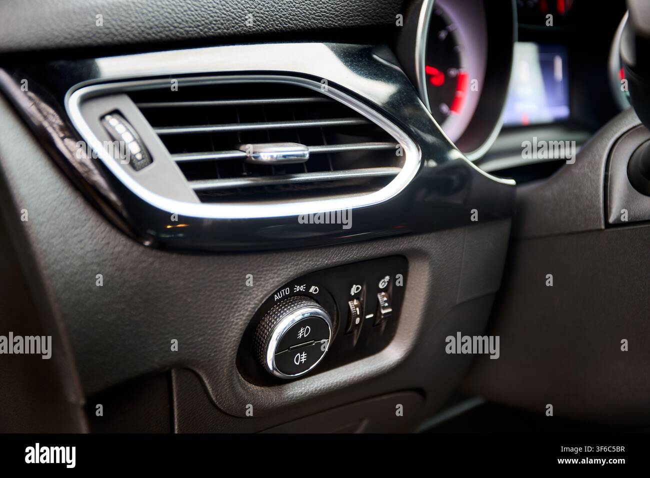 Dashboard headlight switch control panel with air vent in modern car interior showing automatic light modes and adjustments for fog illumination, head Stock Photo