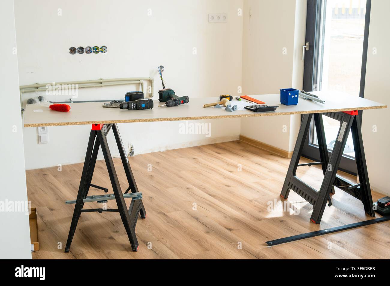 Workbench equipped with various power tools, measuring instruments, and materials during a home renovation.  Stock Photo