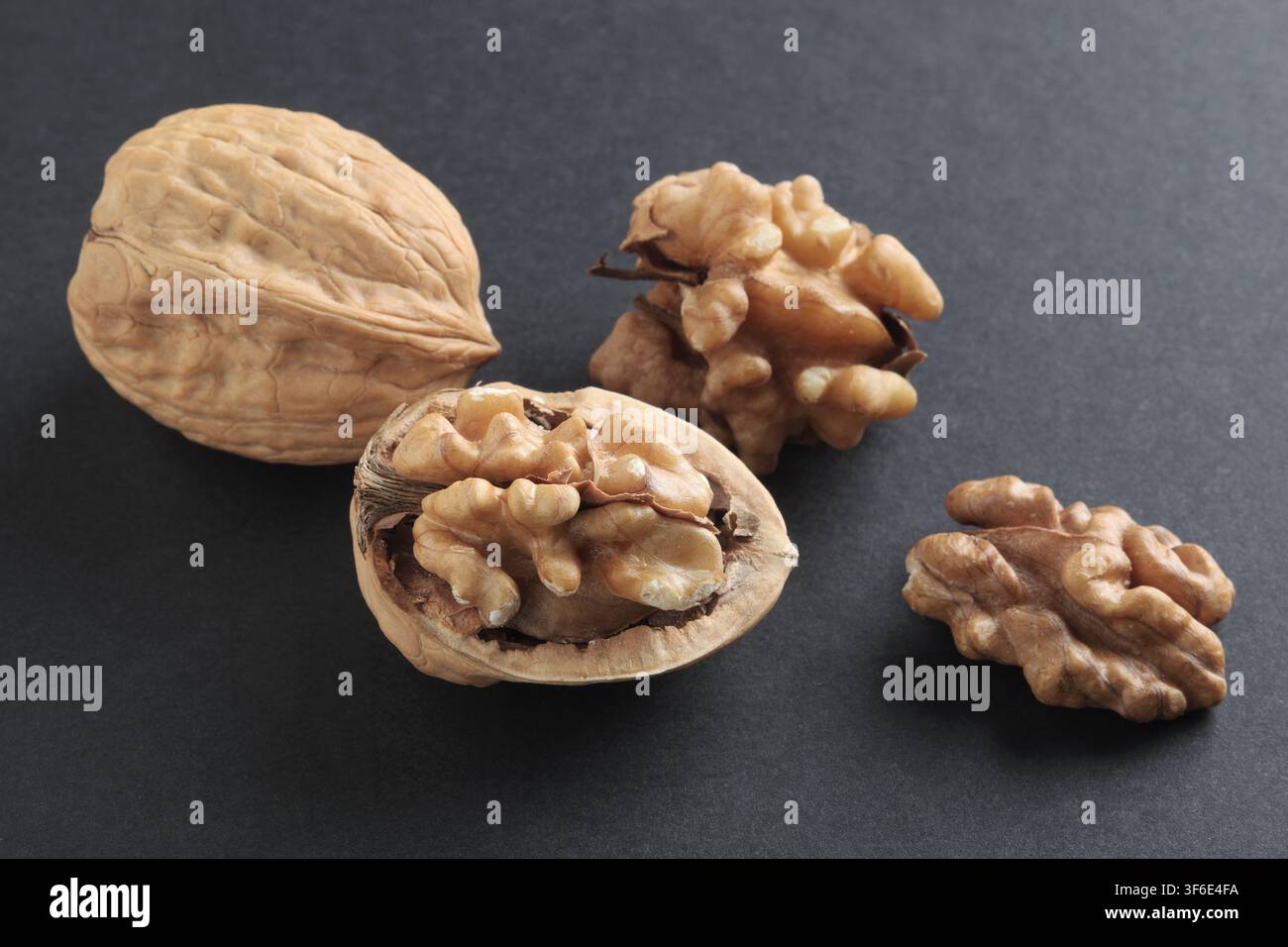 Close up of cracked walnuts on black background Stock Photo