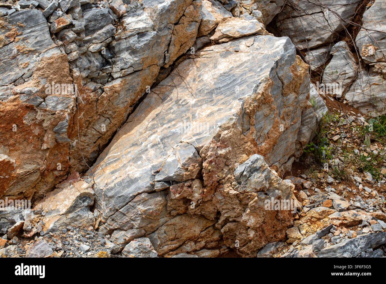 Massive Solid Rock Formation with Earthy Brown Soil and Grey Slate Textures Stock Photo