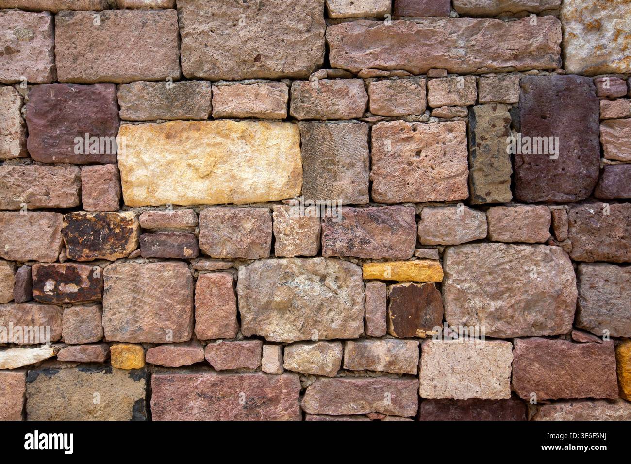Rustic Stone Wall Texture Background with Ancient Multi Colored Blocks Stock Photo