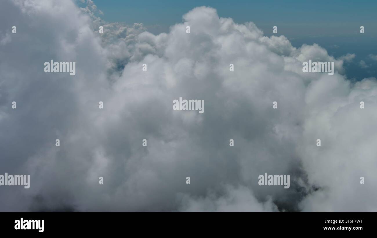 Flying through white clouds over sea Stock Photo