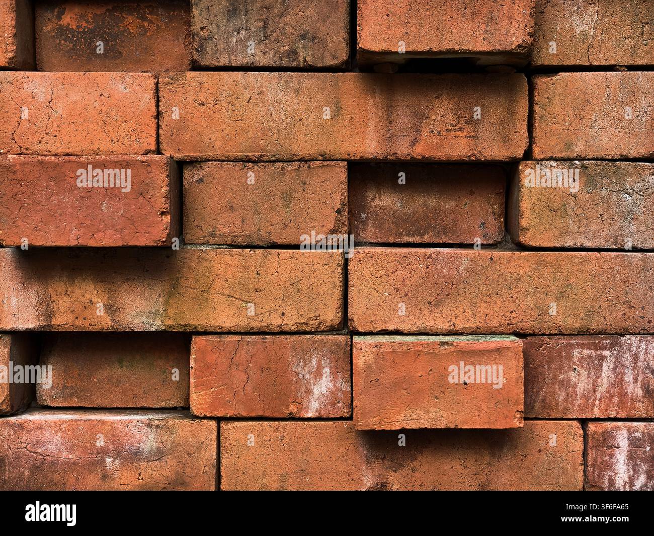 Red brick wall texture with uneven stacked pattern, industrial clay brickwork background. Stock Photo