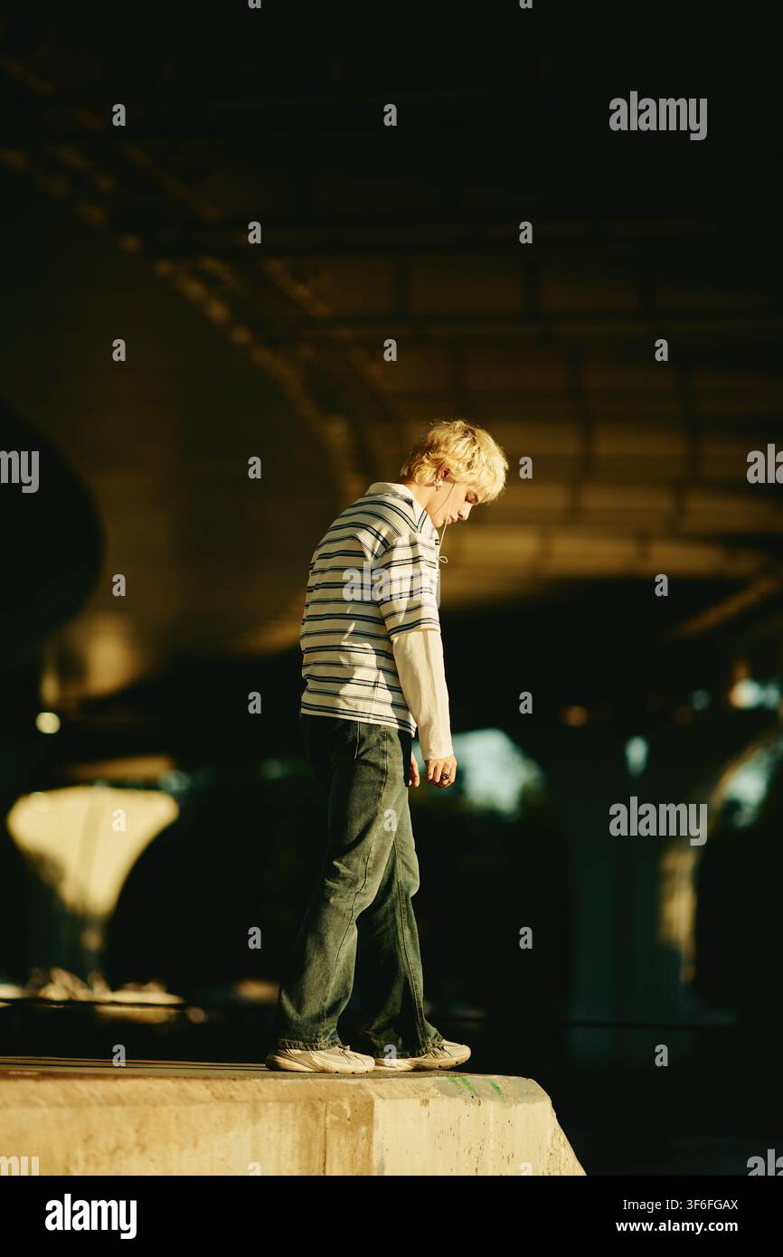 Man Walking Outdoors under Bridge in City Stock Photo