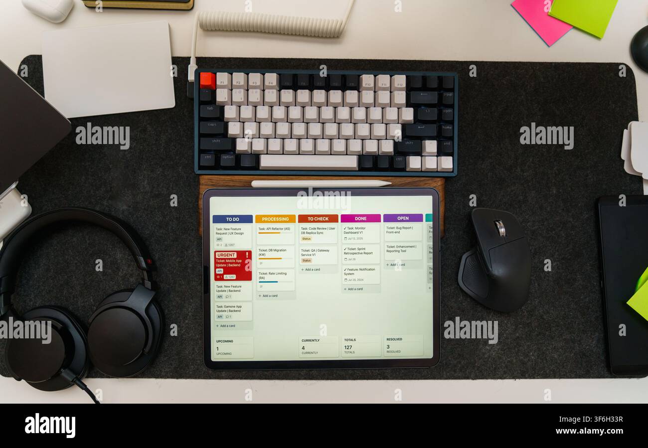 Software Engineer Development Workspace Top View Flat Lay Setup. Overhead view of a modern tech desk setup with a digital tablet displaying a project Stock Photo