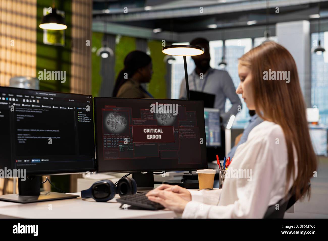 Female software developer in tech startup office struggling to fix app errors while coding. Young employee dealing with computer glitches while coding in software development company Stock Photo