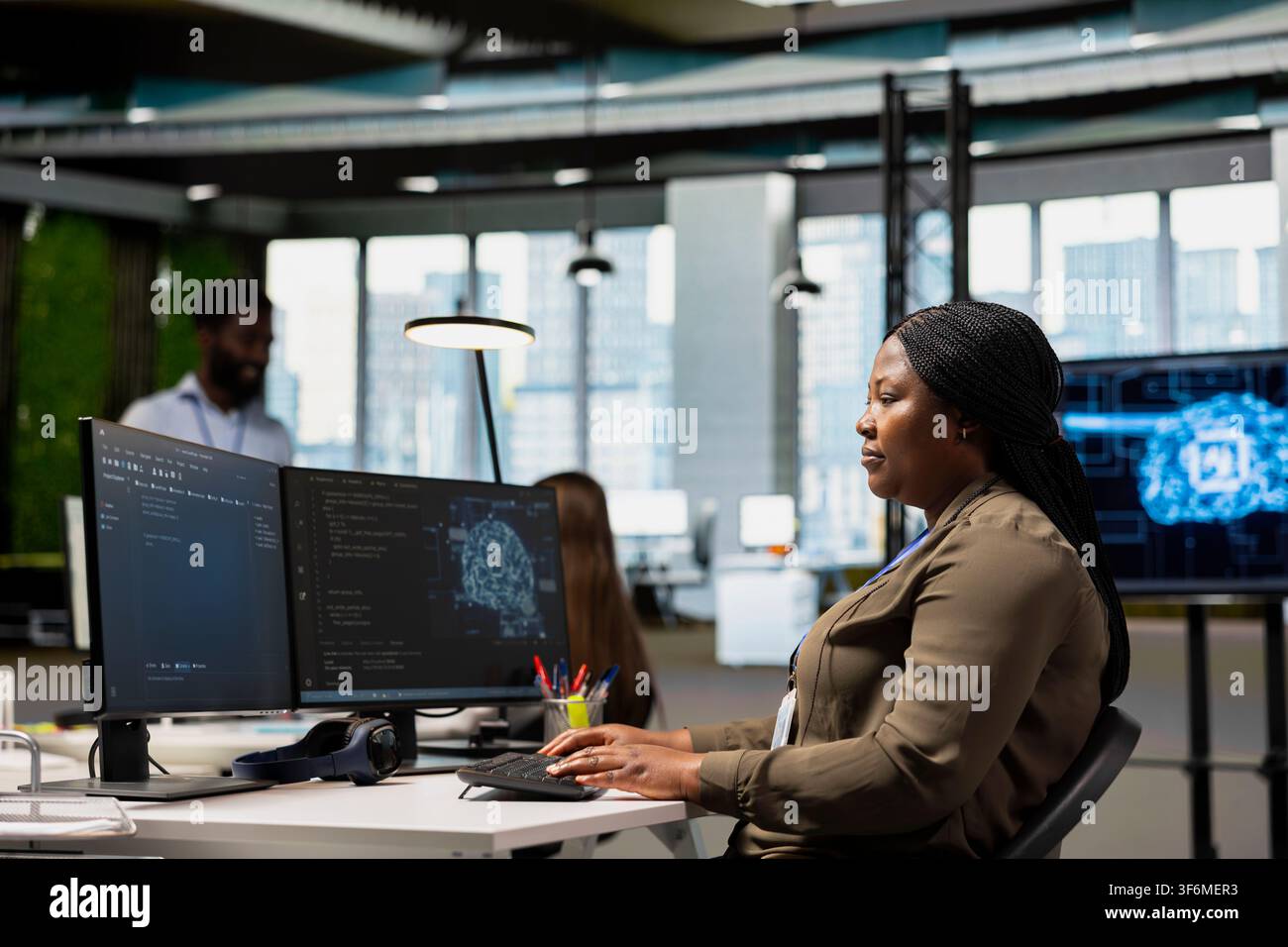 System administrator in office using AI on computer to streamline app development. IT professional at desk using PC to run debugging programs with machine learning technology Stock Photo