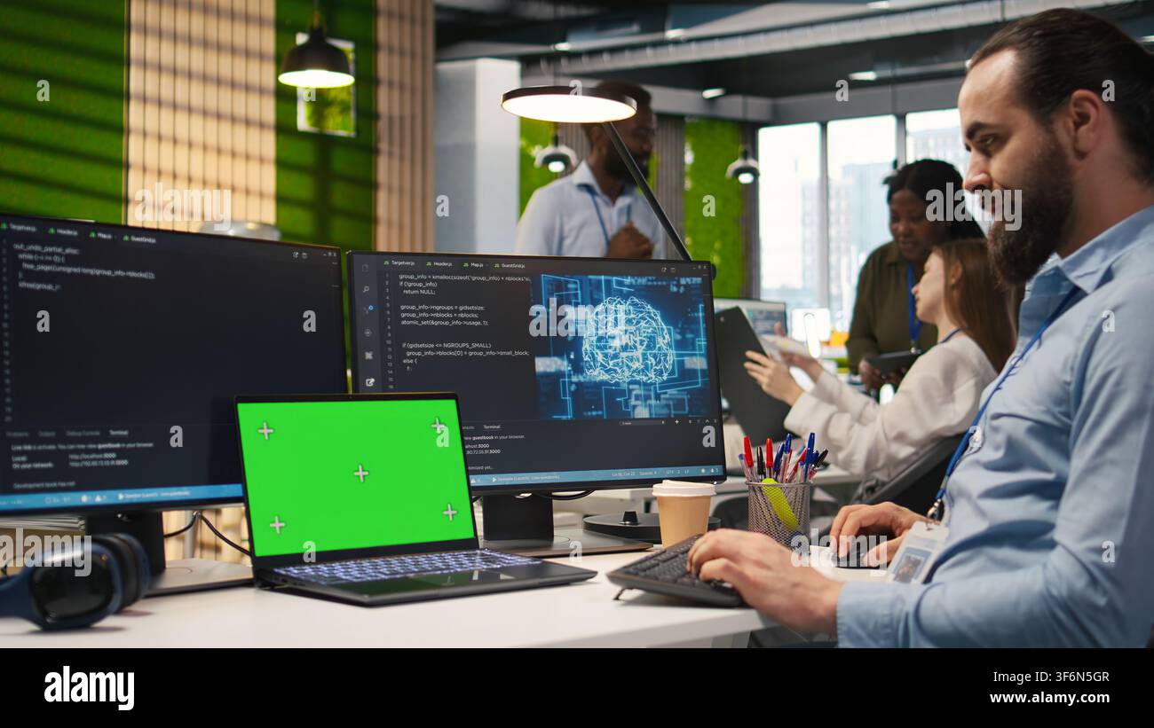 Admin in office using isolated screen laptop, automating repetitive tasks with AI scripts. IT expert using artificial intelligence on chroma key device to speed up feature implementation, camera A Stock Photo