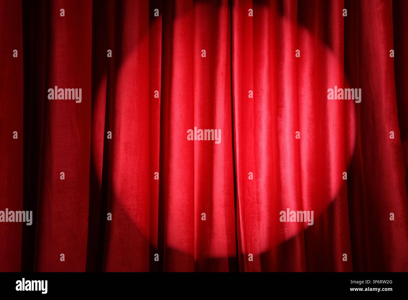 Shining spotlight on red curtain Stock Photo