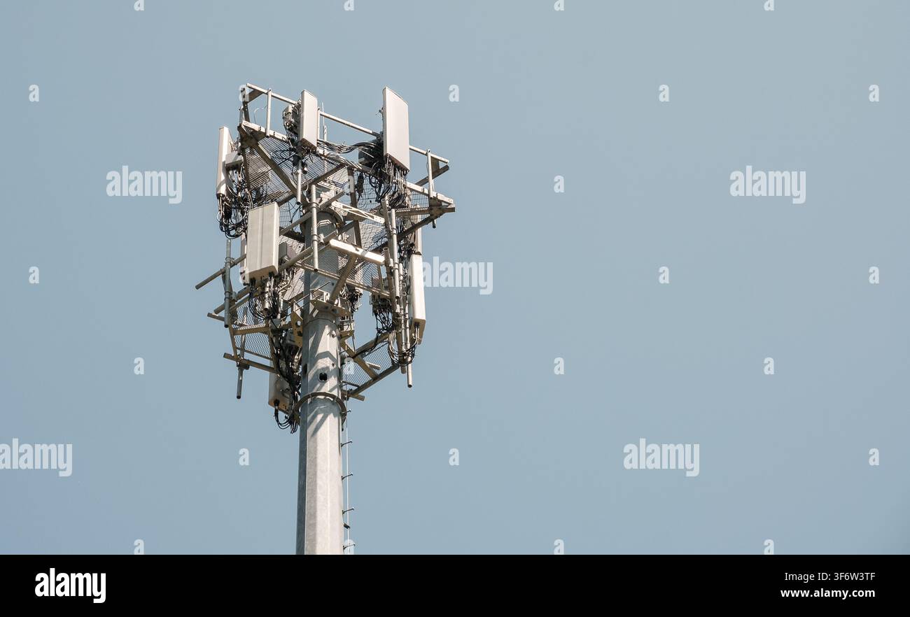 Close-up of a telecommunications cell tower with antennas against a clear sky Stock Photo