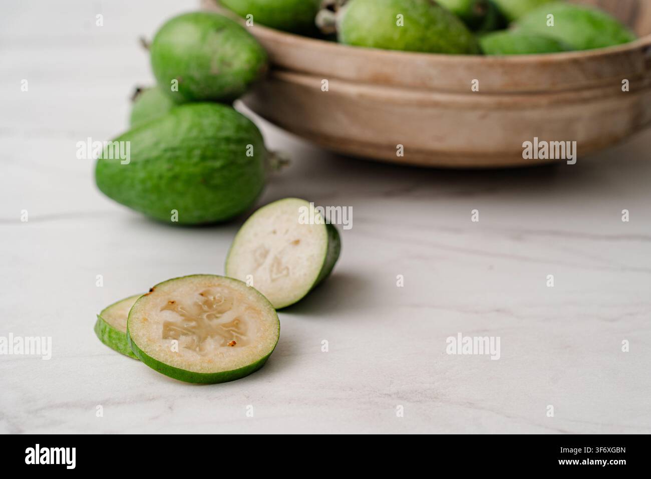 Fresh feijoa fruit sliced on a countertop Stock Photo