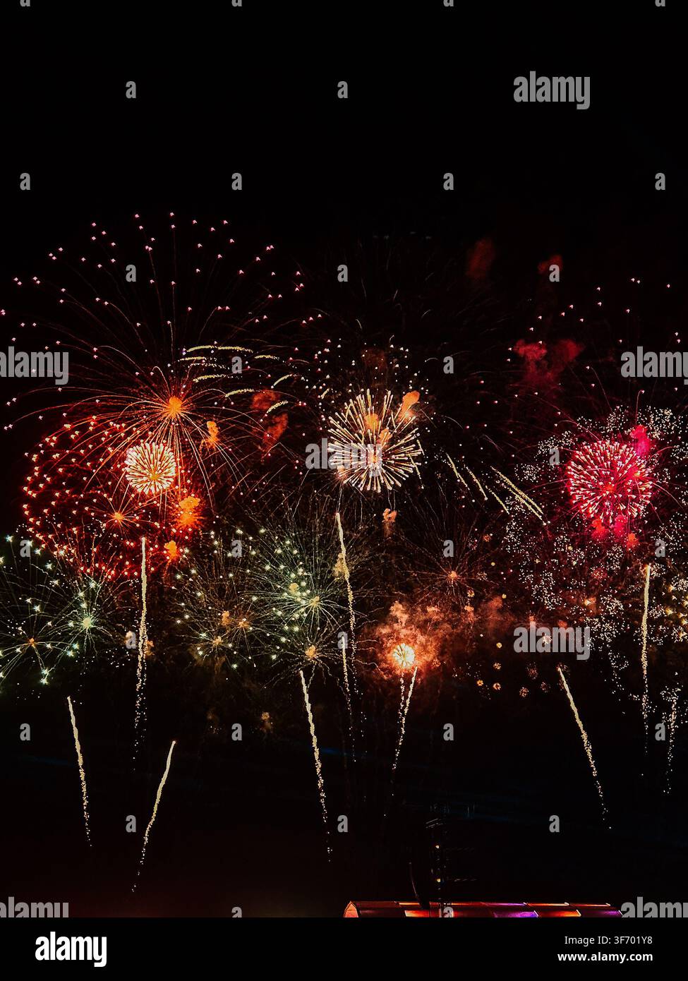 Colorful fireworks exploding in the dark night sky during a festive celebration Stock Photo