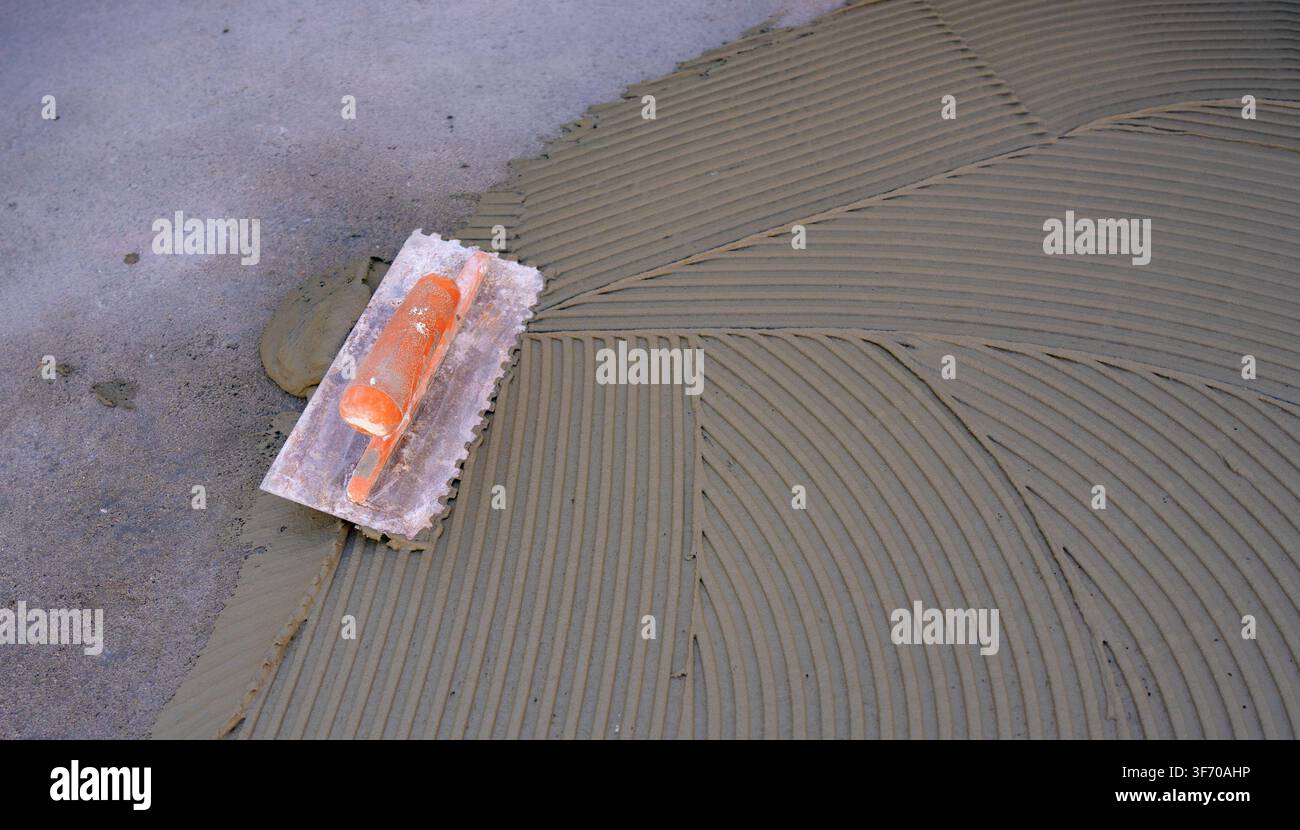 Gray Cement Adhesive Prepared for Ceramic Floor Installation Stock Photo
