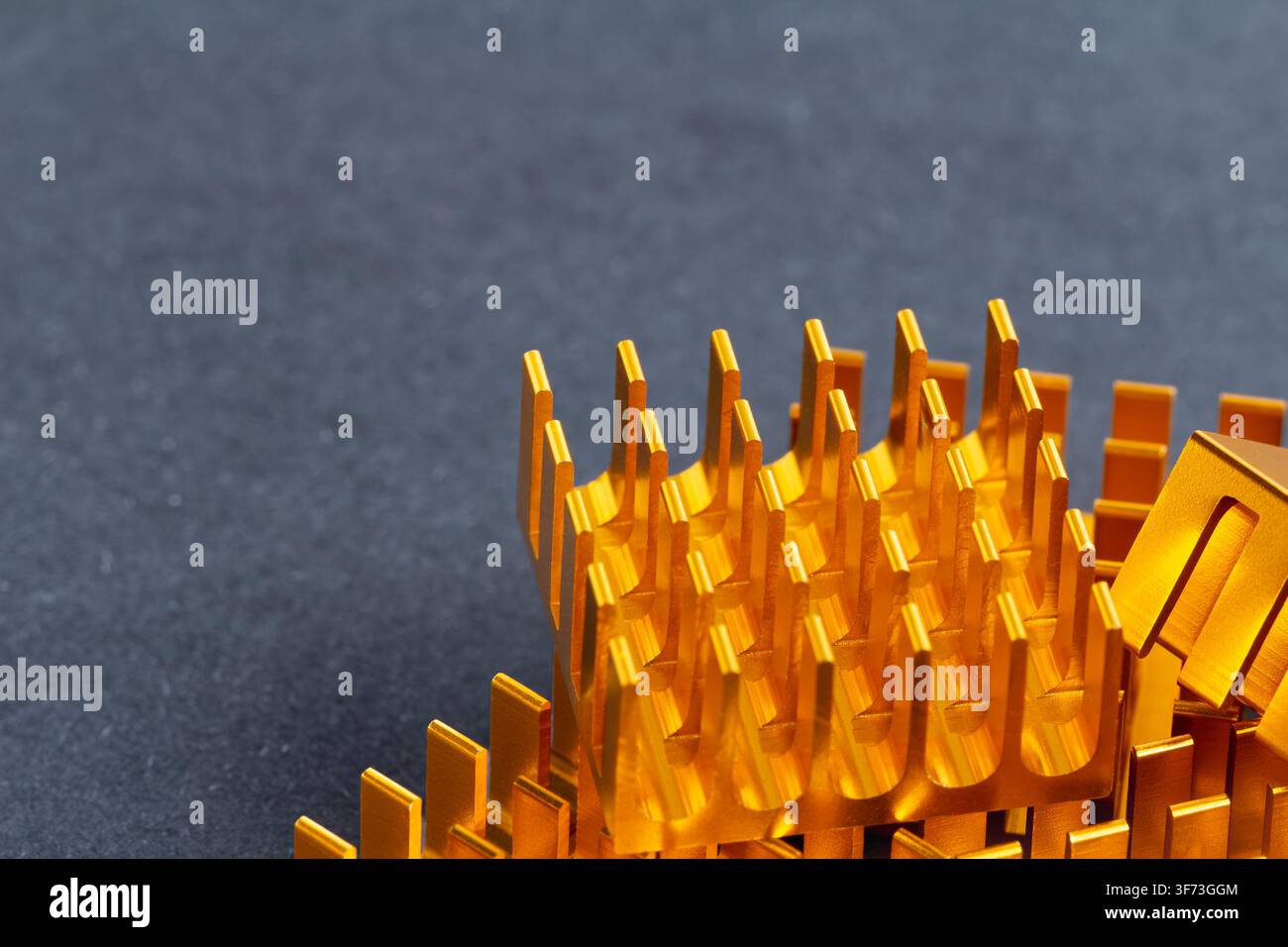 Golden metallic fins stand sharp against a dark surface. Structured design suggests high-tech engineering precision. Clean lines reflect industrial cr Stock Photo