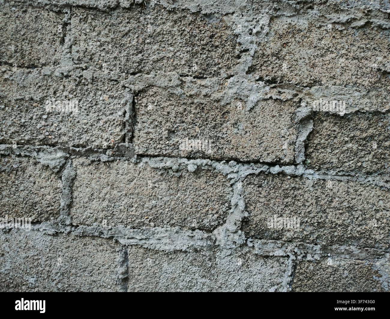 A textured wall built with gray concrete blocks shows visible mortar lines between the rectangular bricks. Stock Photo