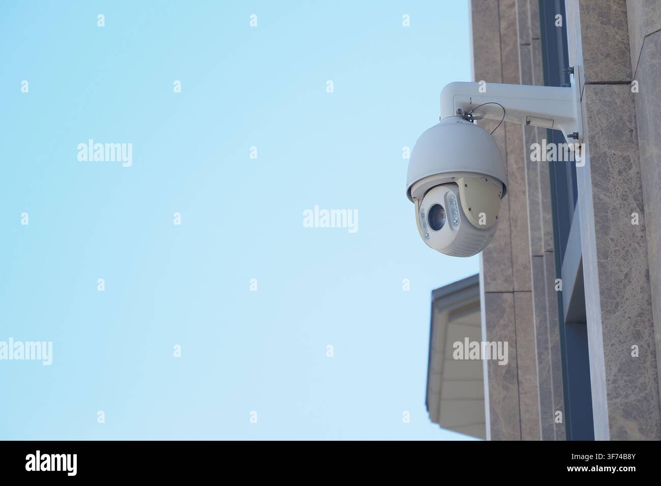 Security camera mounted on a building during the day Stock Photo