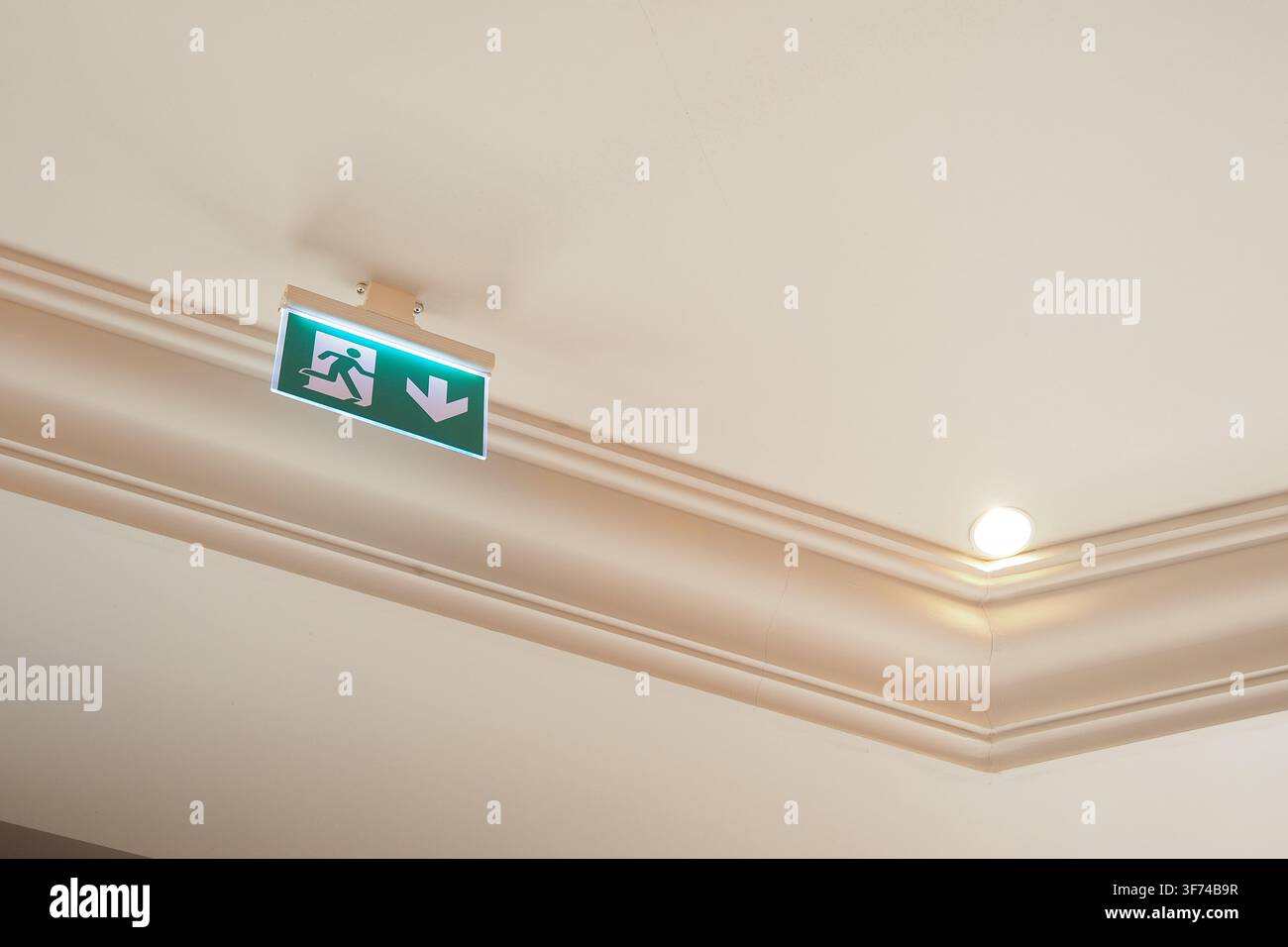 Sign for exit direction on ceiling in building Stock Photo