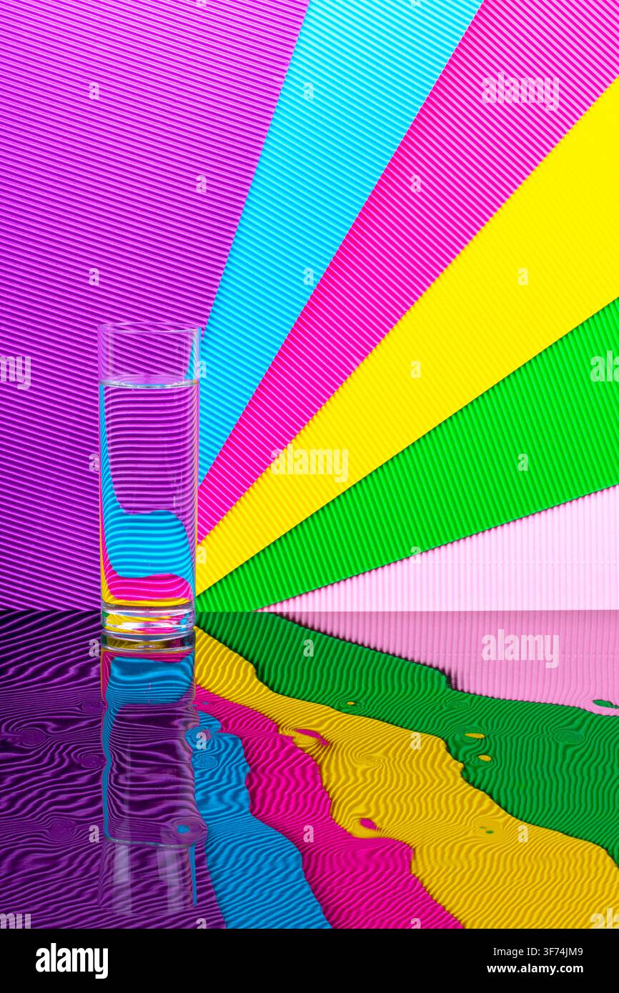 Abstract background with multicolored stripes and a glass of liquid Stock Photo