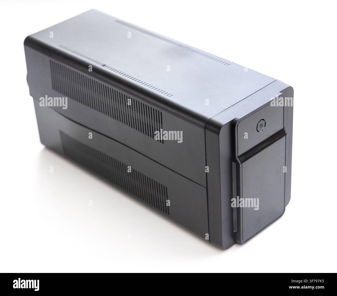 A black uninterruptible power supply device stands on white Stock Photo