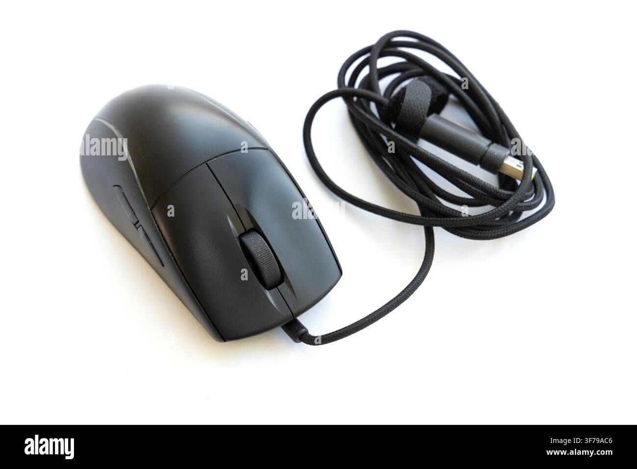A black wired computer mouse rests on a white background Stock Photo