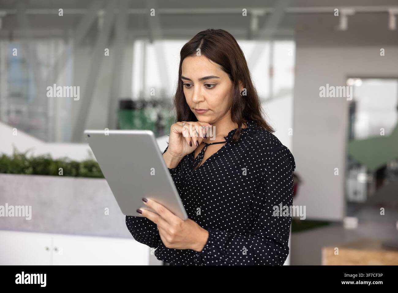 Focused businesswoman analyzing digital data on tablet Stock Photo