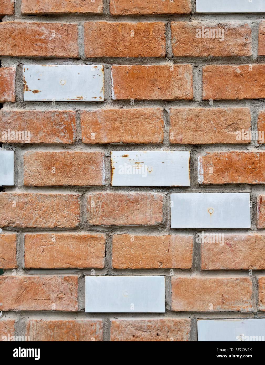Weathered brick wall with blank white ceramic tiles Stock Photo