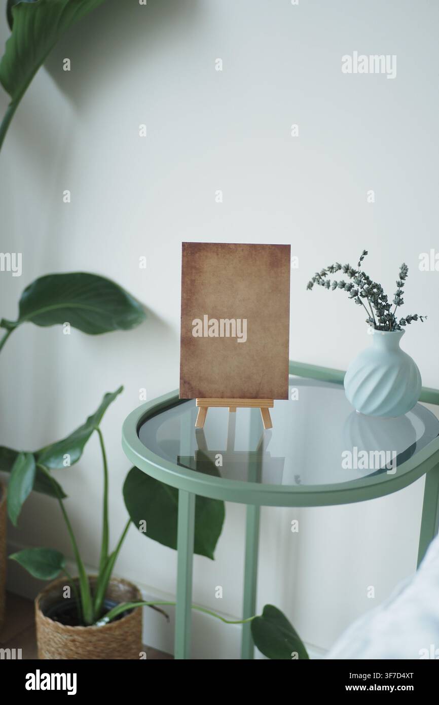 Table with empty canvas and plants in a room Stock Photo