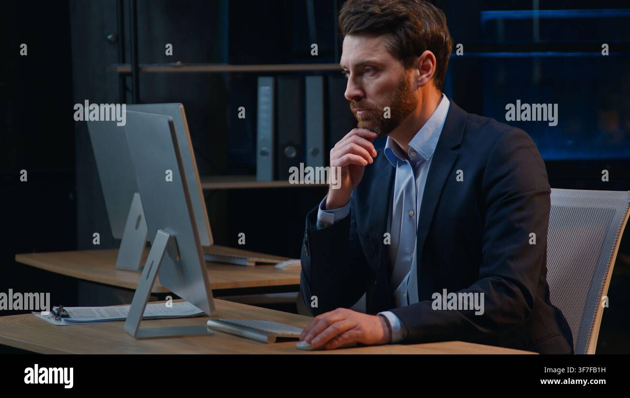 Serious hesitate busy Caucasian business man working with computer think at night office middle-aged businessman male manager work with online Stock Photo