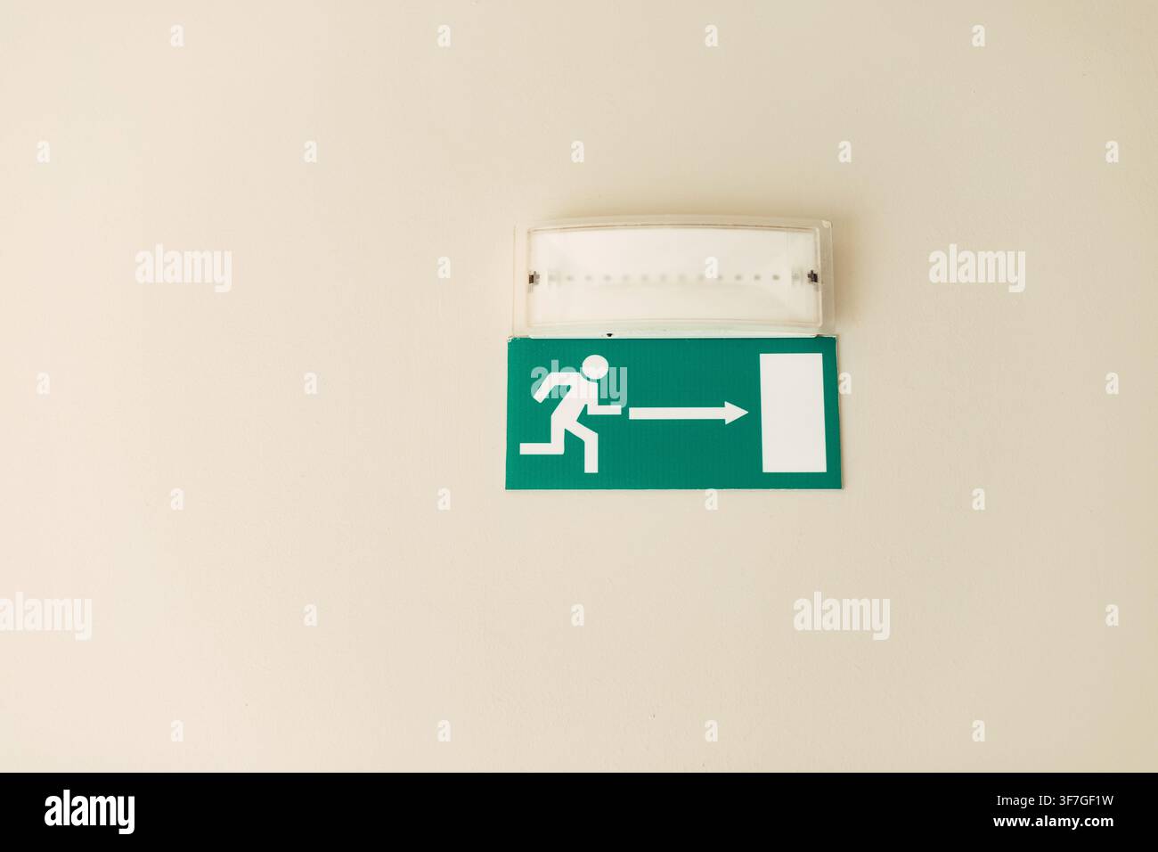 Green emergency exit sign on the ceiling Stock Photo