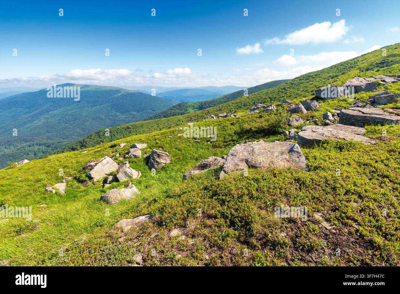 mountain landscape with grass and rock on a slope. view in to the distant valley of carpathian mountains. mountainous scenery of ukraine in summer. gr Stock Photo