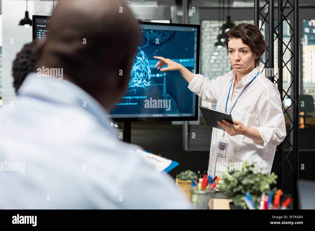 Startup IT employees discussing deep learning tech roadmap during briefing session. Technicians developing neural network applications in office, analyzing system performance metrics after QA testing Stock Photo