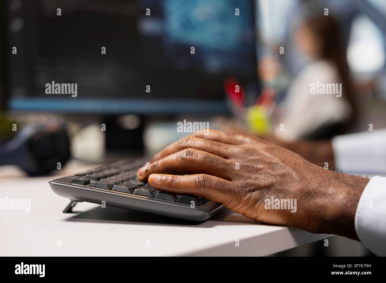 Close up of engineer typing on keyboard in office, using AI on computer to streamline app development. Worker writing code at desk using PC to run debugging programs with machine learning technology Stock Photo