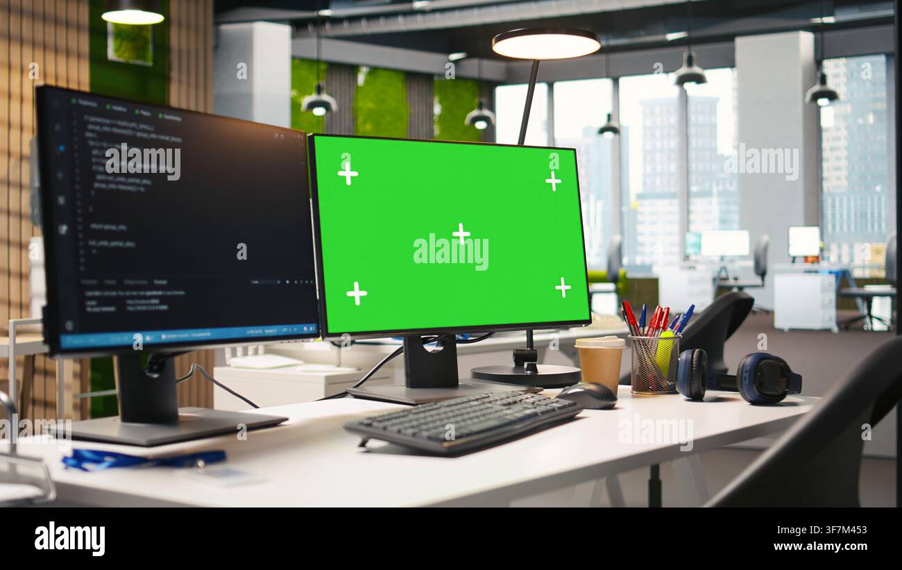 Empty startup office with green screen PC and artificial intelligence program running on monitors. Mockup computer display in AI industry startup workspace leveraging machine learning technology Stock Photo