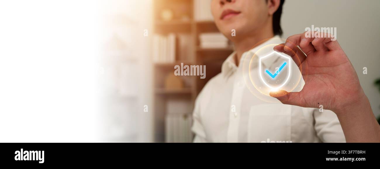 Man holding virtual shield icon with checkmark for security and protection Stock Photo