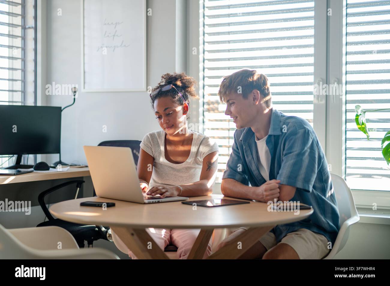 University students working together on laptop during study session. Stock Photo