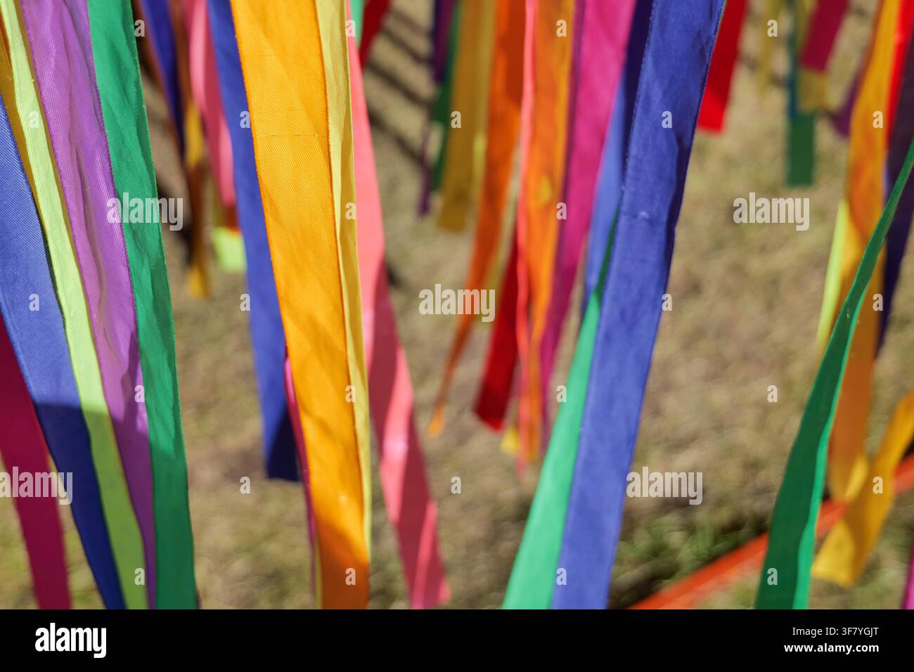 Vibrant multi colored satin ribbons hanging backdrop Stock Photo