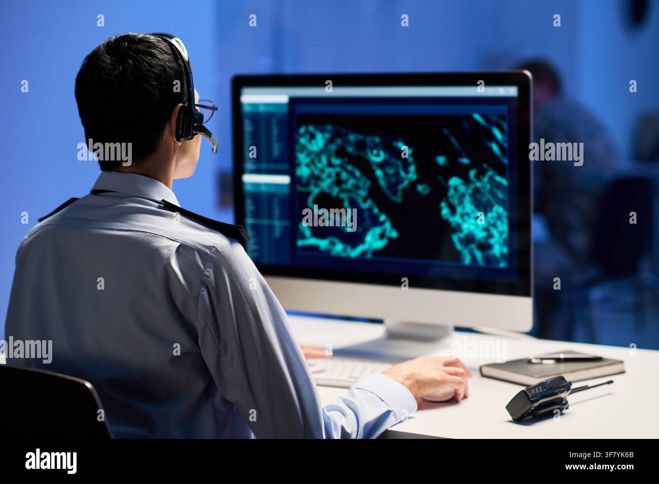 Man in Uniform Working at Security Control Room Computer Stock Photo