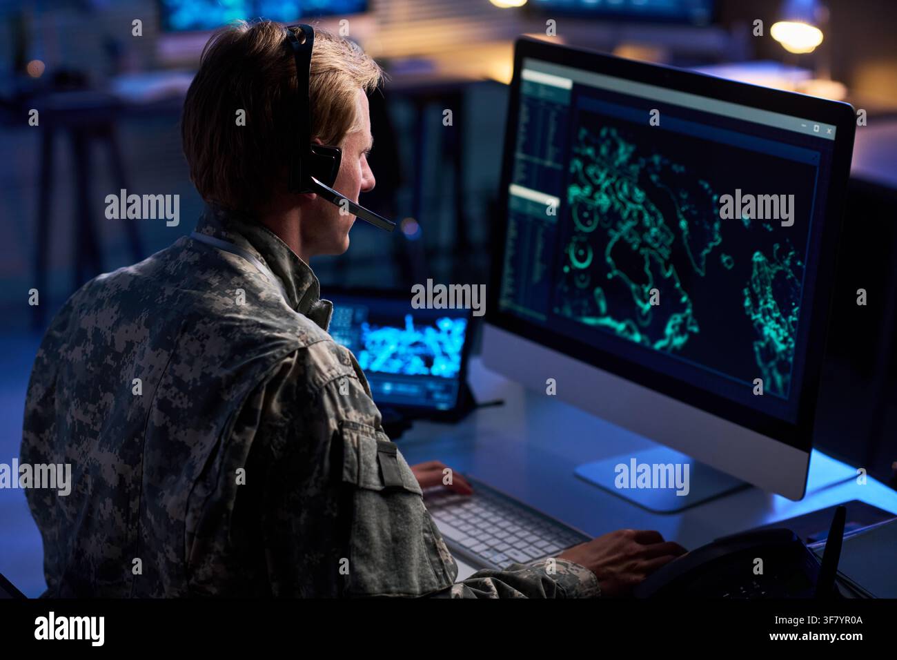 Military Officer Wearing Headset Analyzing Digital Map on Computer Screen Stock Photo