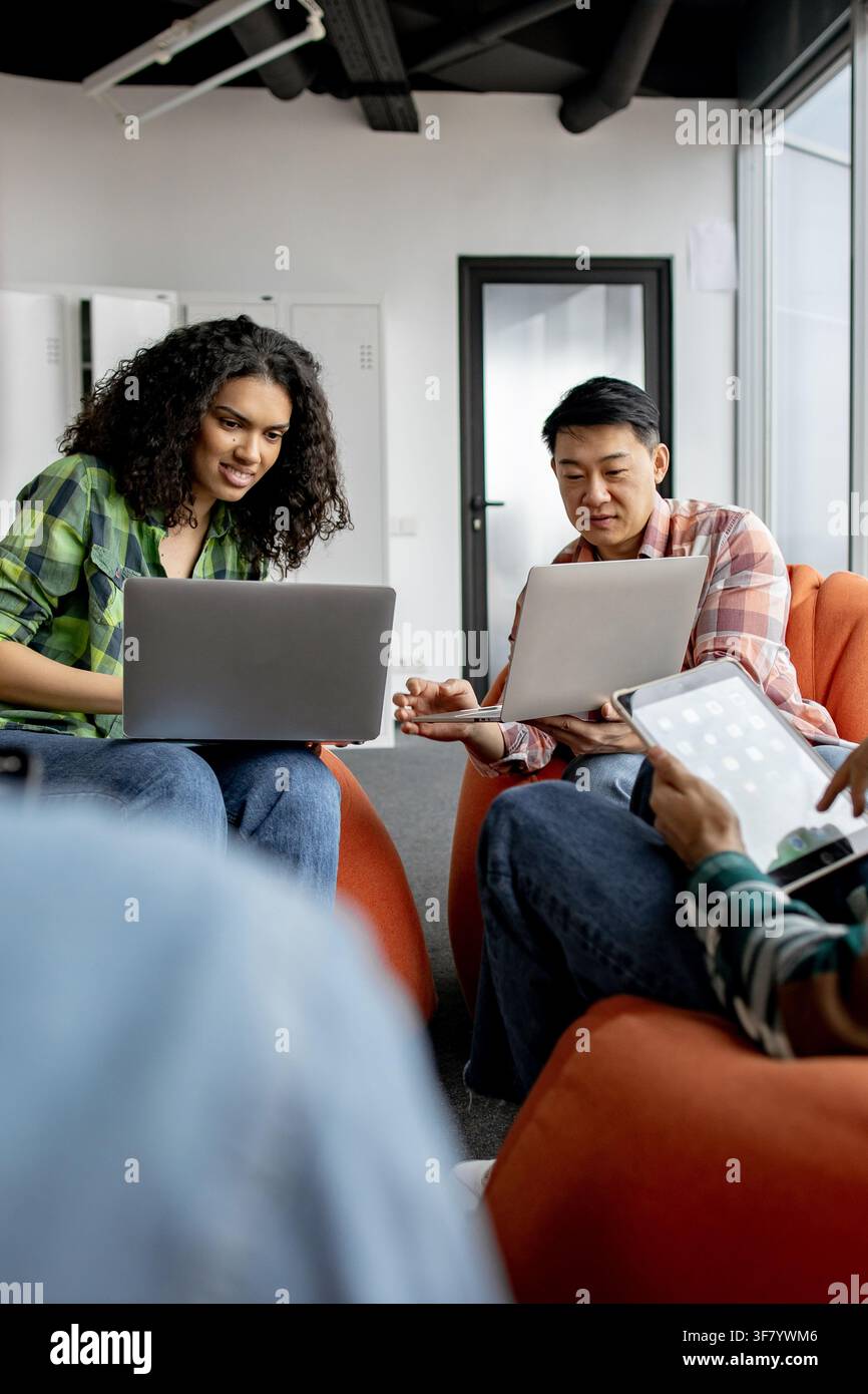 Diverse group collaborating on laptops Stock Photo