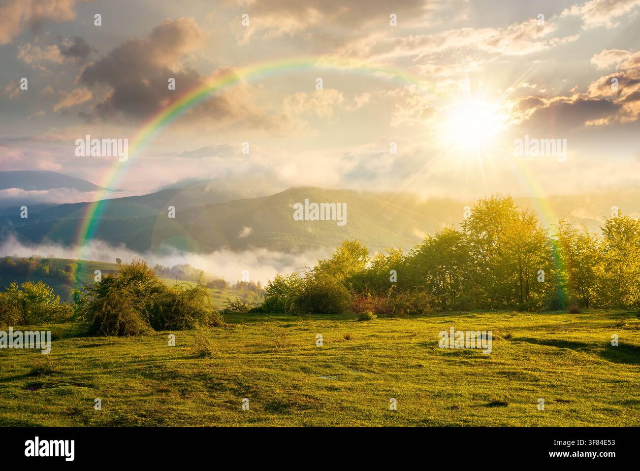 sunset over carpathian mountain landscape with fog. outdoor adventure image for stunning view of meadow. mountain field and rolling countryside valley Stock Photo