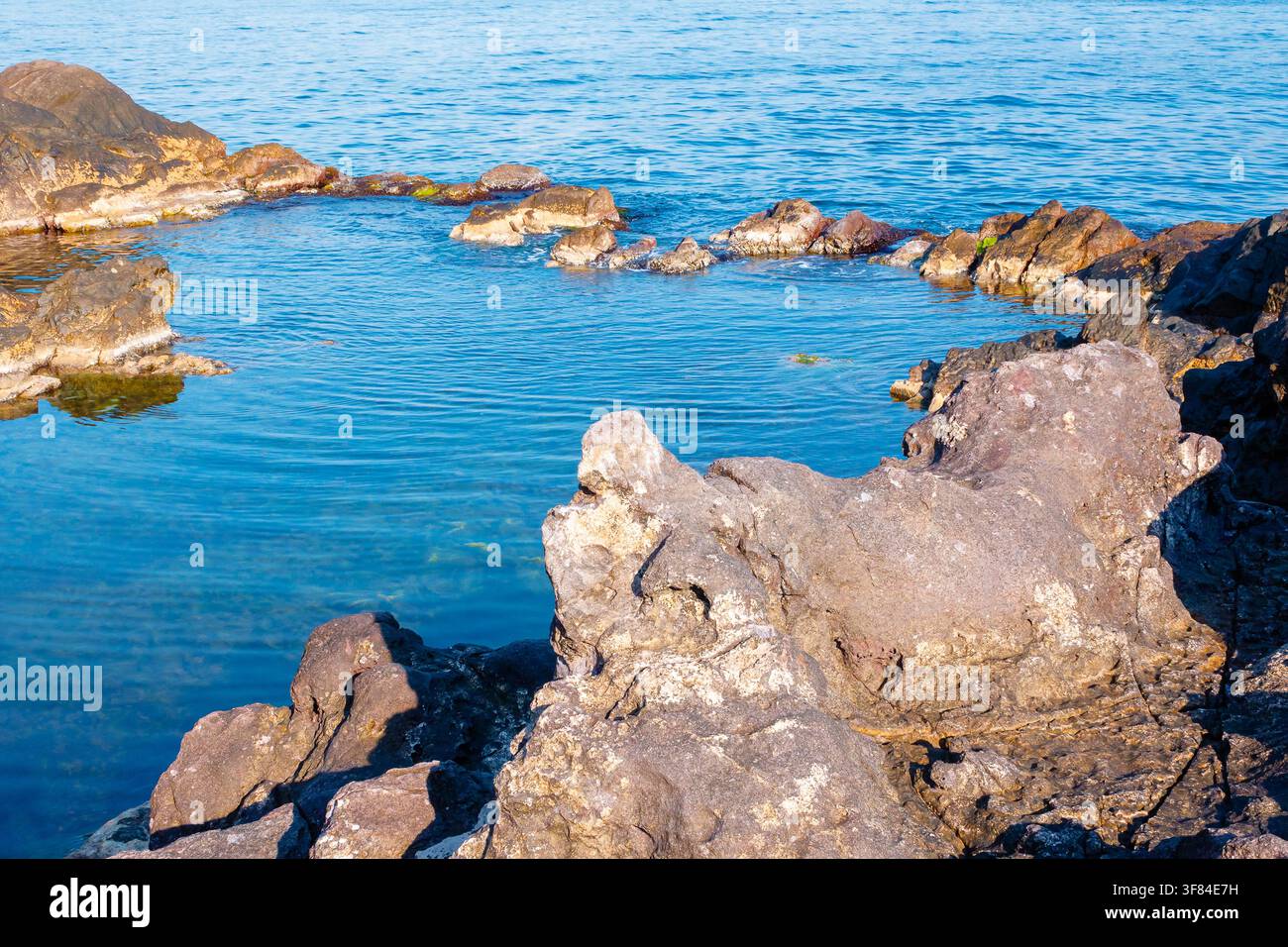 peaceful rock reflection in the sea water. calm summer vacation at the black sea. sunny weather Stock Photo