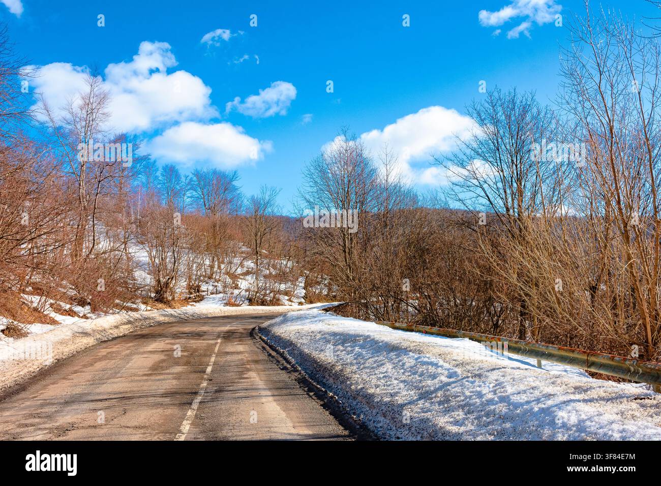 road through Carpathian mountain landscape in winter. travel countryside background. snow covered hills. sunny day Stock Photo
